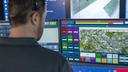 Dispatcher wearing headset and looking at Avtec Scout screen with Teldio map