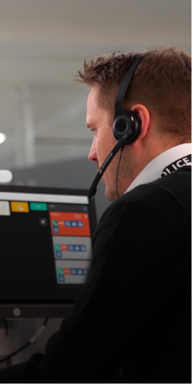 Image of white male worker wearing headset and looking at computer screen